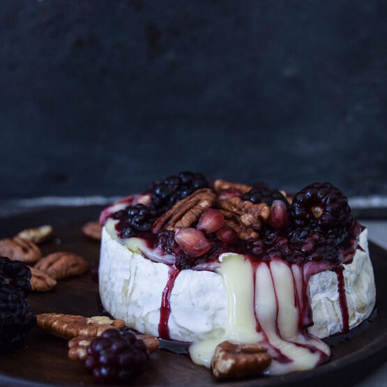 Baked Reunion Cheese: A wheel of reunion cheese is topped with fresh berries and walnuts before baked till molten. Served with toasted baguette slices.