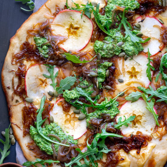 Apple Flatbread: Seasonal apples, caramelized onions, arugula, arugula pesto, and gouda cheese make this simple yet flavorful dish.