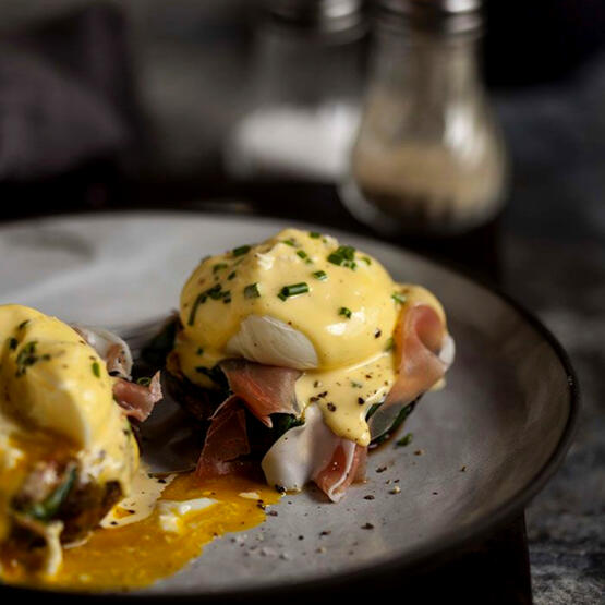 Creamtop Royal Eggs: Poached eggs are served atop a roasted creamtop mushroom, mist spinach, and prosciutto. Topped with a decadent hollandaise and fresh cut spring onions.