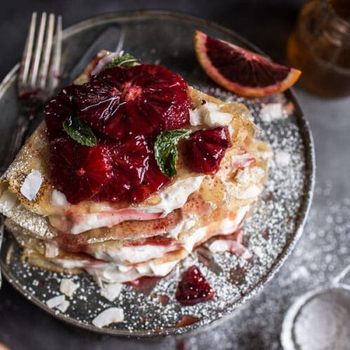 Blood Orange Crêpes: Thin crêpes folded with chantilly creme and chunks of blood orange. Topped with powdered sugar, sliced blood orange, and fresh mint.