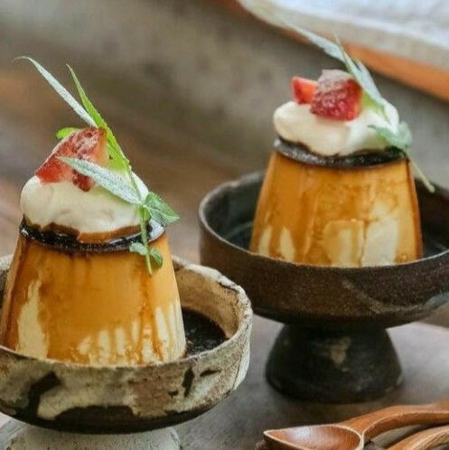 Flan: A delicious, silky custard topped with a caramel sauce, whipped cream, and fresh rolanberries.